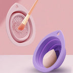 Pink and purple silicone cleaning tools with a brush and sponge on a pink background