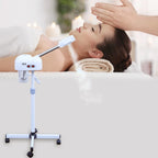 Woman receiving a facial treatment with a handheld device in a spa setting.