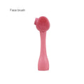 Pink face brush on a white background