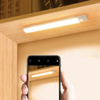 Smartphone taking a photo of a light strip on a wooden surface