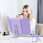 Woman using a purple makeup mirror with a stand in a room setting.