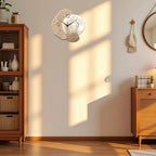 Decorative wall clock on a wall with wooden furniture and decor items in a room.