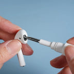 Close-up of a person using a small tool to adjust or fix an AirPod.