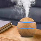 Wooden diffuser emitting steam on a wooden surface with a blurred background