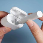Person inserting a wireless earbud into a white charging case against a blue background