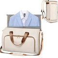 White duffel bag with brown leather straps, light blue blazer, and white shirt inside, beige backpack on white background