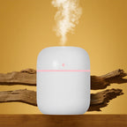 White humidifier with steam rising on a wooden surface against a yellow background