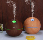 Two wooden diffusers with steam rising from them on a wooden surface.